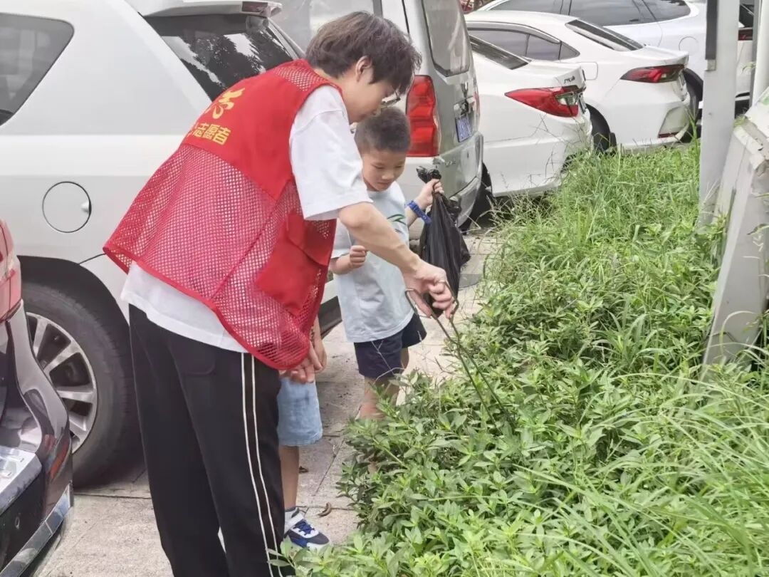志愿者带领社区儿童在户外捡拾垃圾